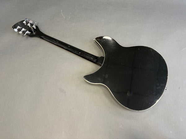 Black electric guitar back view showing body and neck with tuning pegs on grey background