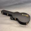 Gibson hard shell guitar case with black exterior and gold latches for Les Paul style guitar