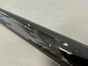 Close-up of black glossy guitar neck with multiple dings and scratches on the back side showing wear and tear