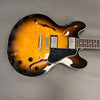 Semi-hollow body electric guitar with sunburst finish and dual humbucker pickups on gray background
