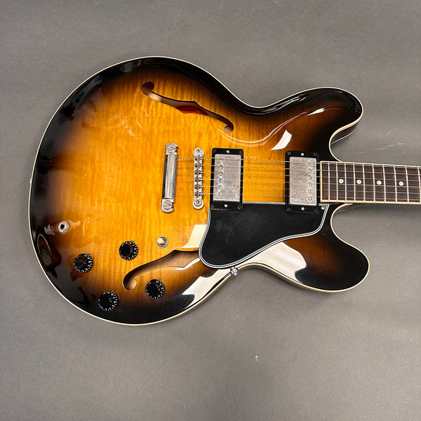 Semi-hollow body electric guitar with sunburst finish and dual humbucker pickups on gray background