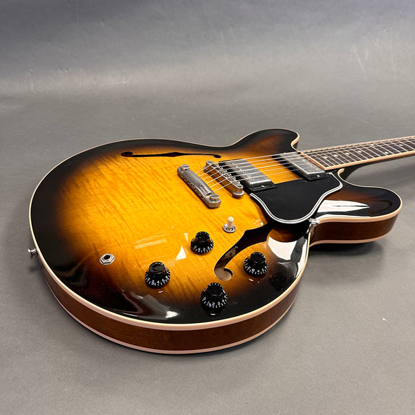 Semi-hollow electric guitar with sunburst finish and dual humbucker pickups on gray background