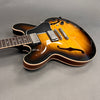 Semi-hollow electric guitar with sunburst finish, dual humbucker pickups, and rosewood fretboard on gray background