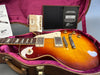 Gibson Les Paul electric guitar in sunburst finish with cream pickguard, humbucker pickups, and gold control knobs, displayed in pink plush-lined hard case with Gibson Custom Certificate of Authenticity and warranty documents.
