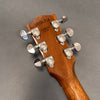 Back of acoustic guitar headstock showing Grover tuning pegs, serial number 09034718, and Made in U.S.A. stamp on natural wood finish