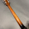 Glossy sunburst finish guitar neck with chrome tuning pegs on gray background