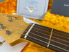 Close-up of Fender Custom Shop guitar headstock and fretboard on yellow plush case lining with Fender Custom Shop tag in background