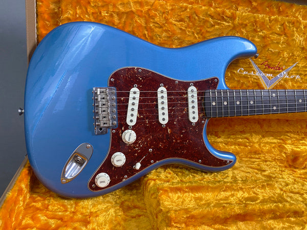 Blue Fender Stratocaster electric guitar with tortoiseshell pickguard and three single-coil pickups in vintage orange plush-lined case