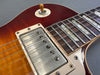Close-up of vintage sunburst electric guitar body showing metal humbucker pickup, rosewood fretboard with mother-of-pearl inlays, and pickup selector switch set to treble