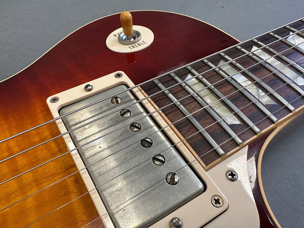Close-up of vintage sunburst electric guitar body showing metal humbucker pickup, rosewood fretboard with mother-of-pearl inlays, and pickup selector switch set to treble