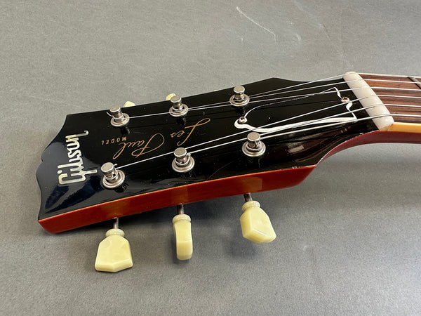 Close-up of Gibson Les Paul vintage guitar headstock with tuning pegs on gray background