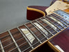 Close-up of electric guitar fretboard with pearl block inlays and metal frets on cherry red body guitar from Coffee House Guitars product listing