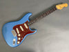 Fender Stratocaster electric guitar in metallic blue finish with tortoiseshell pickguard and rosewood fretboard on gray background