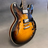 Semi-hollow body electric guitar with sunburst finish, dual humbucker pickups, and f-holes on guitar body
