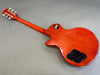 Back view of cherry red electric guitar with mahogany neck and black control cavity cover on gray background