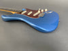Blue electric guitar with tortoise shell pickguard, white control knobs, and rosewood fretboard on gray background