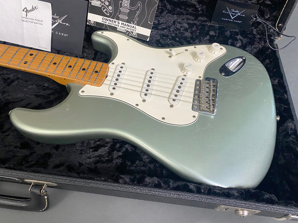 Fender Stratocaster electric guitar in metallic green finish with maple neck and white pickguard inside black plush guitar case with Fender owner's manual and custom care booklet