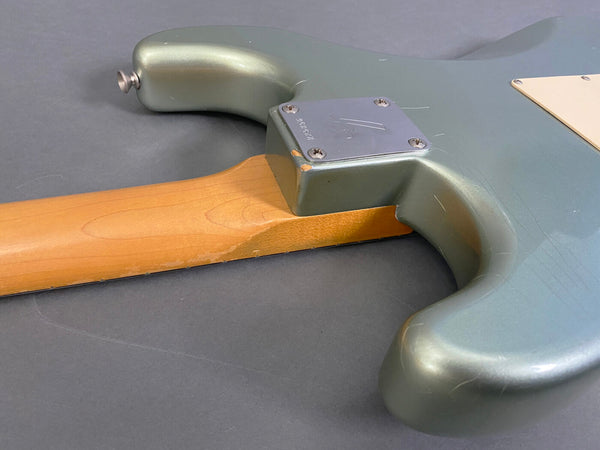 Close-up of vintage electric guitar neck joint with metallic green body and maple neck showing wear and wood grain at Coffee House Guitars product listing