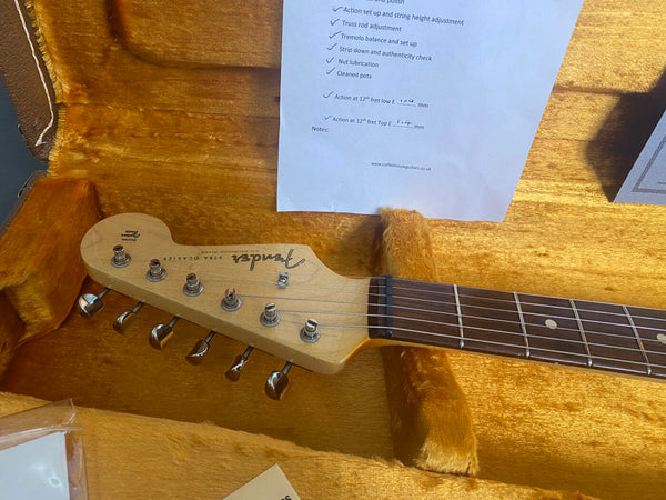 Fender Squier Stratocaster maple neck guitar headstock with tuning pegs in orange plush-lined guitar case displaying setup checklist from Coffee House Guitars