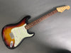 Fender Stratocaster electric guitar with sunburst finish, three single-coil pickups, maple neck, and rosewood fretboard on gray background