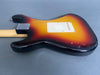 Back view of sunburst finish electric guitar body with maple neck and white backplate on gray background