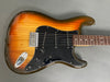 Sunburst electric guitar with black pickguard, three single-coil pickups, and rosewood fretboard on gray background.