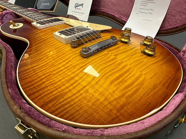 Gibson Les Paul electric guitar with sunburst finish and flame maple top in pink plush-lined hard case, close-up showing pickups and control knobs