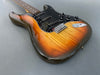 Electric guitar with sunburst finish, black pickguard, and three control knobs on gray background