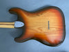 Back view of sunburst electric guitar body with maple neck and six string ferrules on blue background