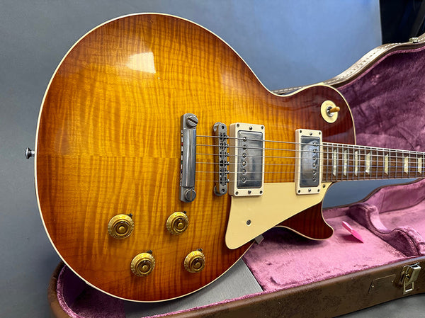 Sunburst finish electric guitar with dual humbucker pickups and four control knobs inside pink-lined hard case