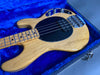 Natural finish electric bass guitar with maple neck and black pickguard in blue plush-lined hard case
