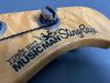 Close-up of Ernie Ball Music Man StingRay bass guitar headstock with tuning peg and string wrapped around it