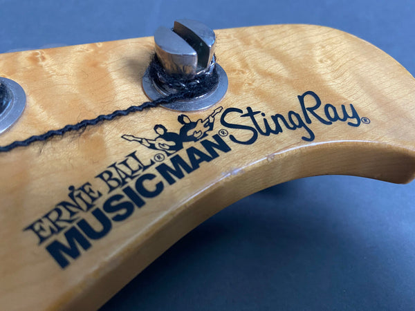 Close-up of Ernie Ball Music Man StingRay bass guitar headstock with tuning peg and string wrapped around it