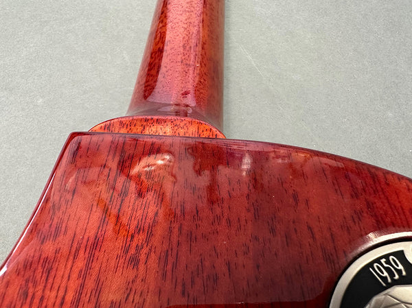 Close-up of glossy mahogany wood neck and back of Coffee House Guitars acoustic guitar with 1959 emblem detail