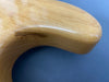 Close-up of natural wood grain and gloss finish on curved part of electric guitar body against blue background
