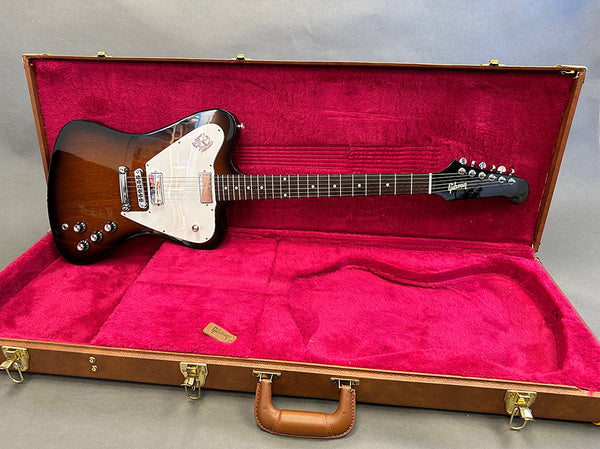 Gibson Thunderbird electric guitar with sunburst finish in open brown hard case with red plush interior, featuring maple and rosewood neck and custom pickguard.