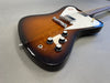 Electric guitar with sunburst finish, white pickguard, chrome bridge, and four black control knobs on gray background