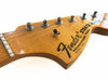 Close-up of Fender Stratocaster electric guitar headstock with tuning pegs, maple wood finish, and string guide on white background