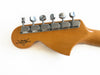 Close-up of Fender Custom Shop wooden guitar headstock with six chrome tuning pegs on white background