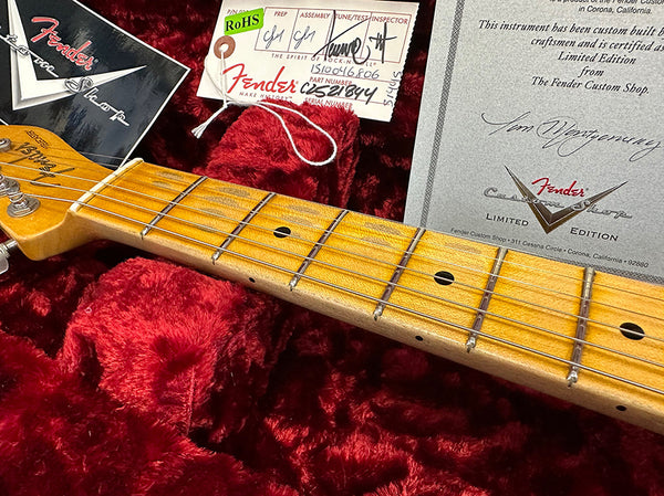 Close-up of a Fender Custom Shop electric guitar neck with maple fretboard, showing frets and dot inlays, alongside Fender Custom Shop certificate and inspection tags on red plush case lining.
