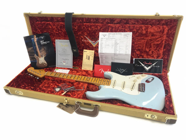 Fender Custom Shop electric guitar in light blue finish with maple neck and vintage-style tuning pegs in tweed hard case with red plush interior, including certificate of authenticity, Fender Custom Shop booklet, strap, tremolo arm, and additional Fender documentation and accessories.