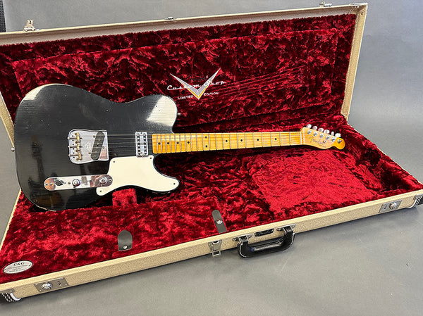 Black vintage Fender Telecaster electric guitar with maple neck resting in open beige hardshell case lined with red plush interior from Coffee House Guitars.