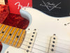 Close-up of light blue Fender Custom Shop electric guitar with maple fretboard and single-coil pickups, displayed on red plush background with Fender Custom Care packaging.
