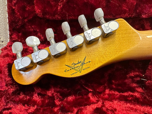 Close-up of Fender Custom Shop Limited Edition guitar headstock with tuning pegs on red plush background