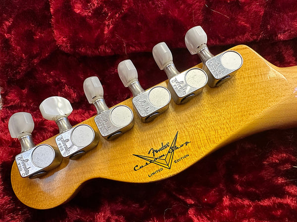 Close-up of Fender Custom Shop Limited Edition guitar headstock with vintage-style tuning pegs on red plush background
