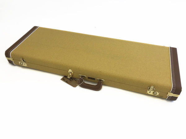 Rectangular tweed guitar case with brown leather corner reinforcements and handle, secured with brass latches, isolated on white background.