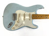 Vintage light blue electric guitar with maple fretboard and white pickguard, showing worn finish and three single-coil pickups.