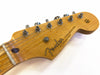 Close-up of Fender Stratocaster guitar headstock showing tuning pegs and wood grain finish