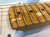 Close-up of maple guitar neck with worn fretboard and metal frets on a light blue electric guitar body from Coffee House Guitars