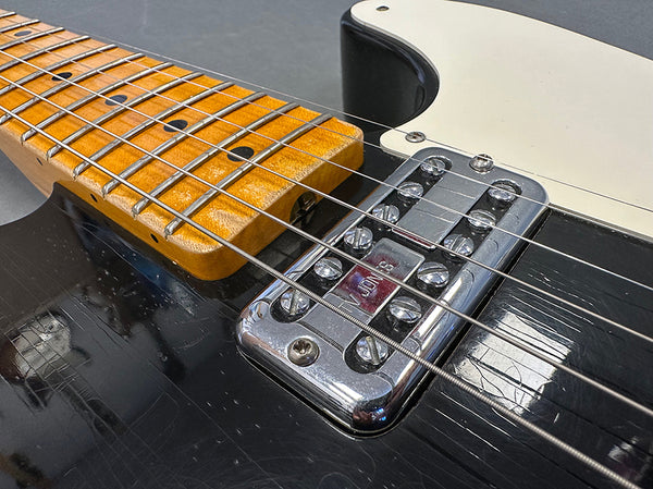 Close-up of electric guitar Voodoo vintage style chrome bridge and maple fretboard with strings at Coffee House Guitars